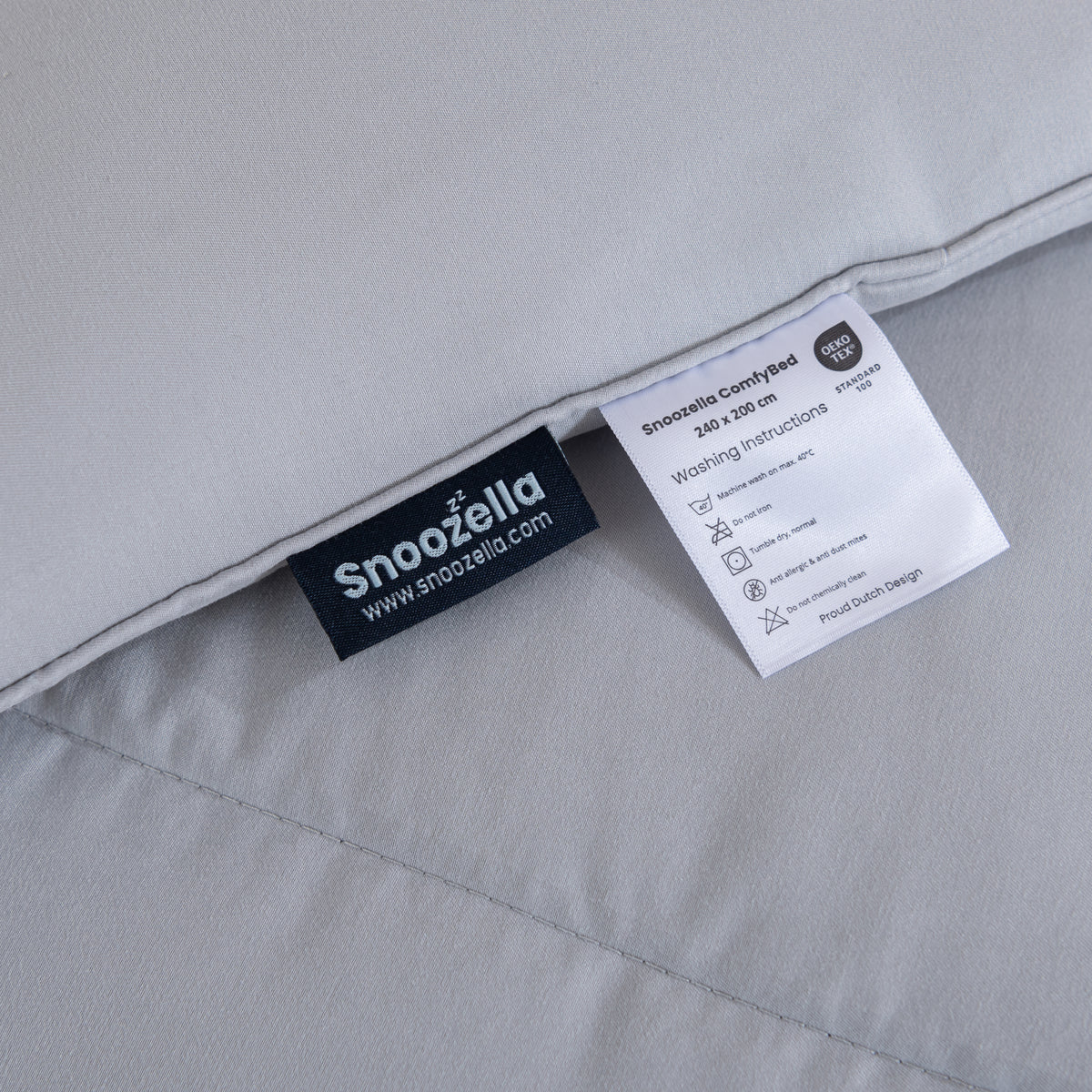 Snoozella ComfyBed Lichtgrijs op een opgemaakt bed – sfeerfoto 5