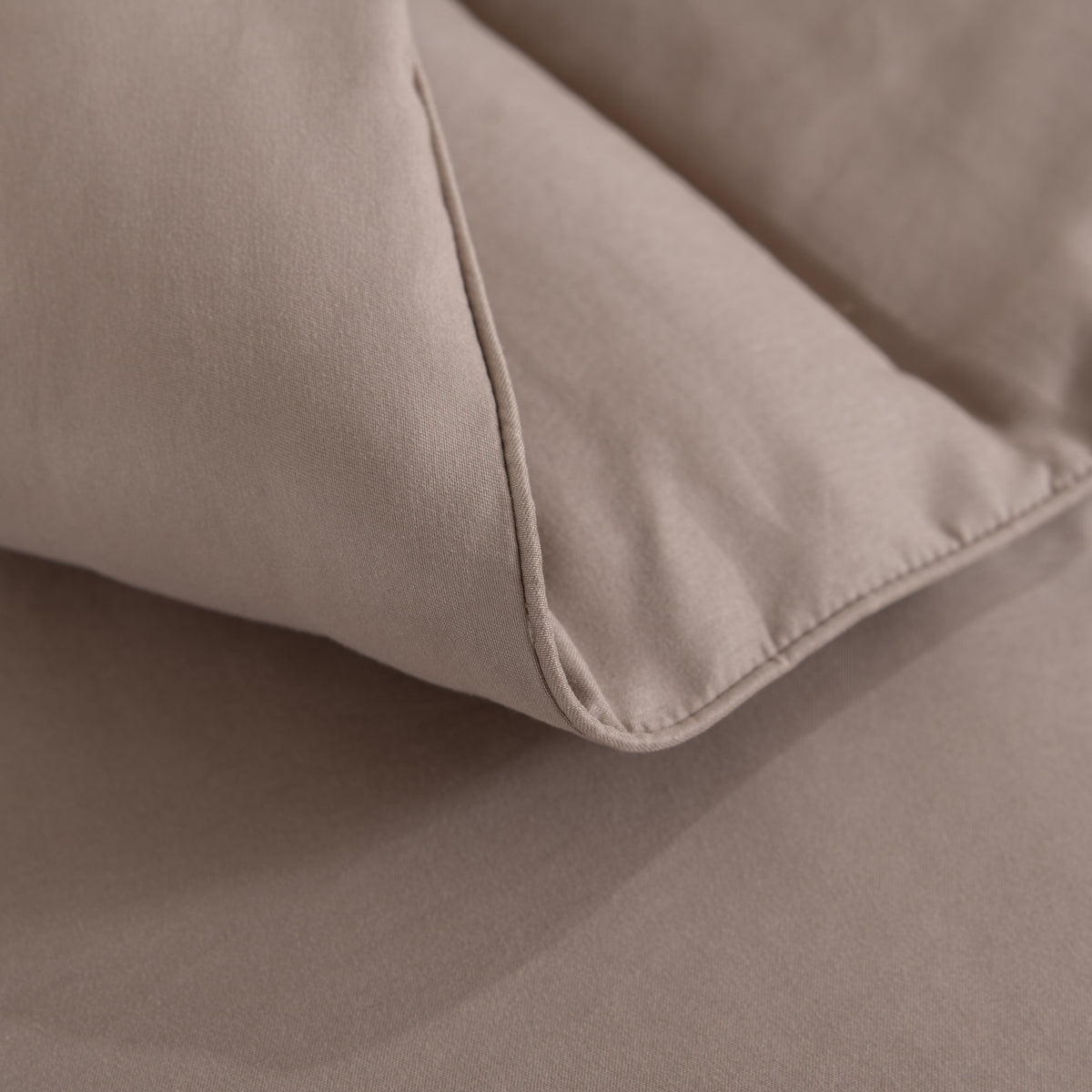 Snoozella ComfyBed Taupe op een opgemaakt bed – sfeerfoto 5