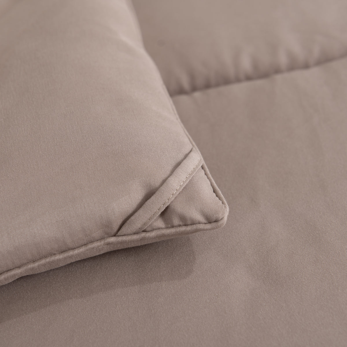 Snoozella ComfyBed Taupe op een opgemaakt bed – sfeerfoto 6