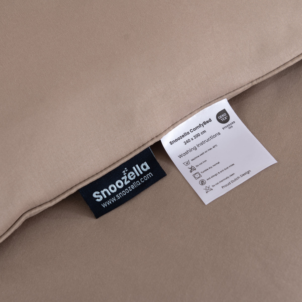 Snoozella ComfyBed Taupe op een opgemaakt bed – sfeerfoto 7