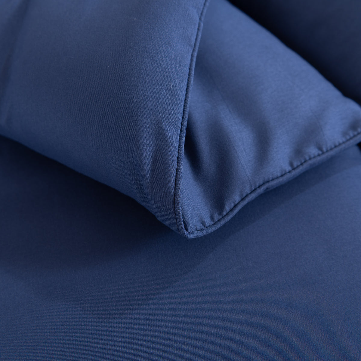 Snoozella ComfyBed Donkerblauw op een opgemaakt bed – sfeerfoto 5