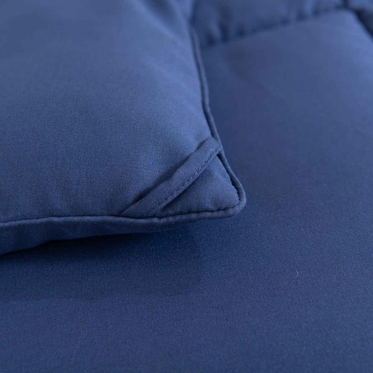 Snoozella ComfyBed Donkerblauw op een opgemaakt bed – sfeerfoto 6