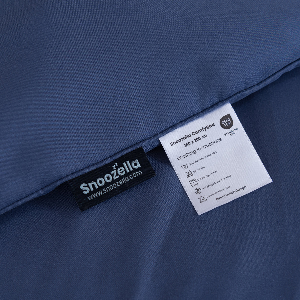Snoozella ComfyBed Donkerblauw op een opgemaakt bed – sfeerfoto 7