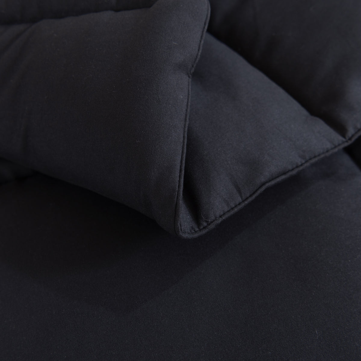 Snoozella ComfyBed Zwart op een opgemaakt bed – sfeerfoto 5