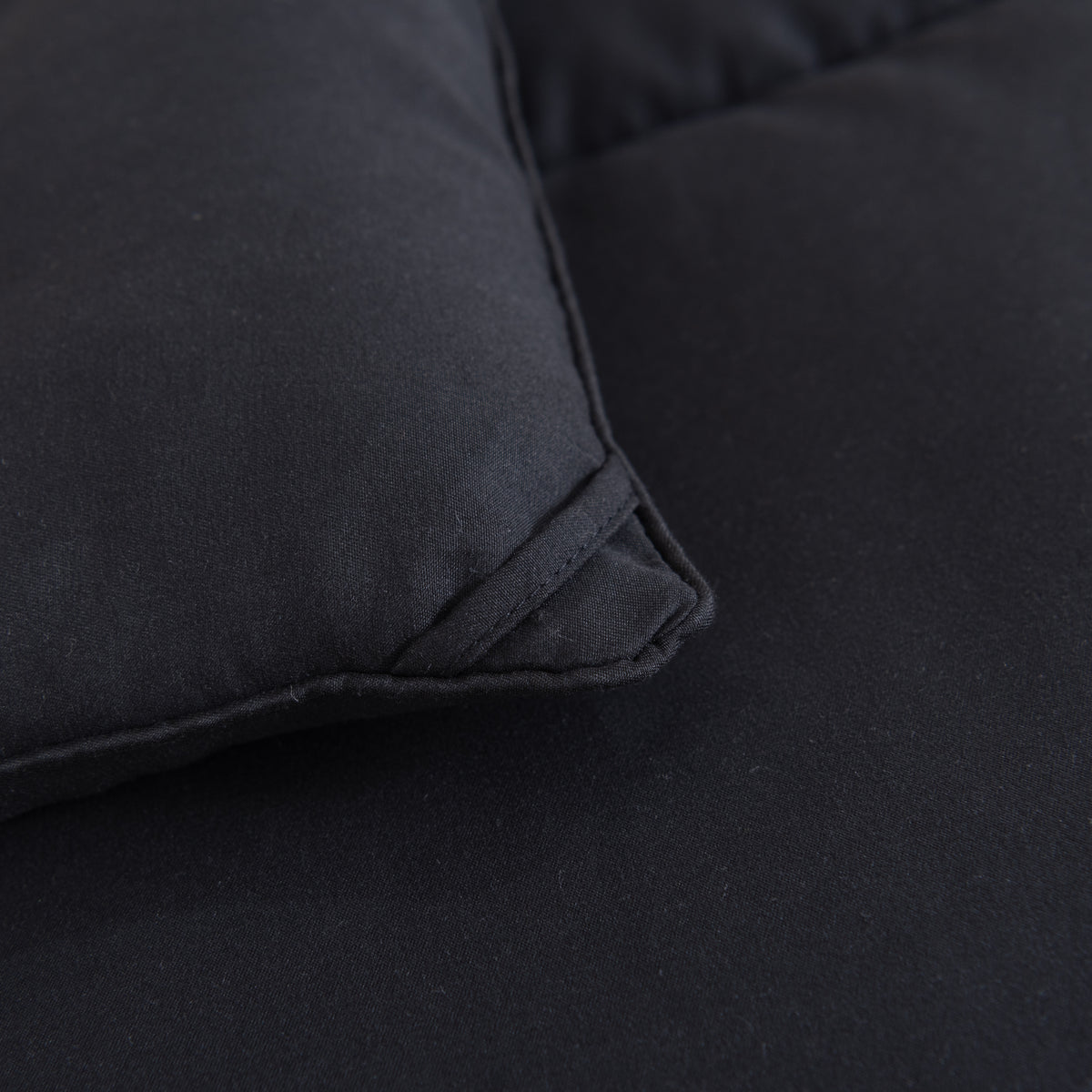 Snoozella ComfyBed Zwart op een opgemaakt bed – sfeerfoto 6