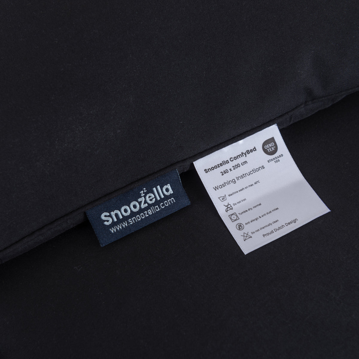 Snoozella ComfyBed Zwart op een opgemaakt bed – sfeerfoto 7