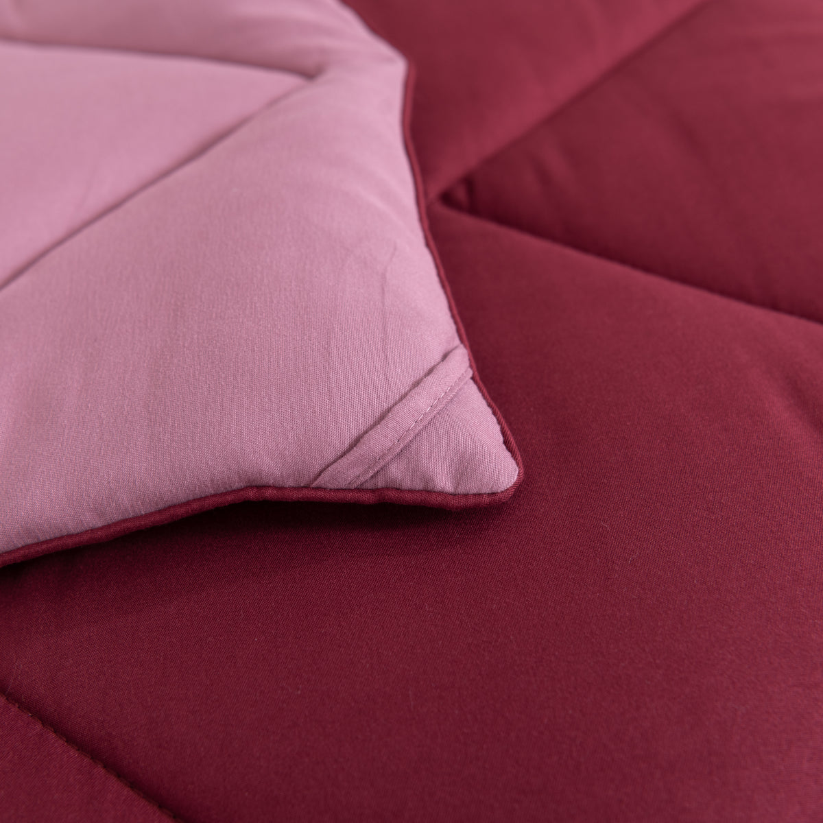 Snoozella ComfyBed Duo Wijn Rood op een opgemaakt bed – sfeerfoto 6